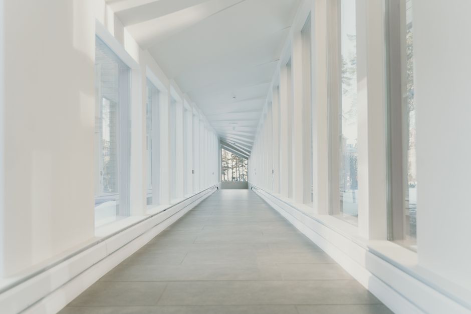 Bright and airy modern hallway with large glass windows showcasing minimalist design.